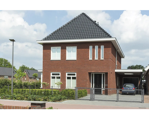 Ansicht eines Einfamilienhauses mit Ziegelfassade, dunklem Dach und Vorgarten