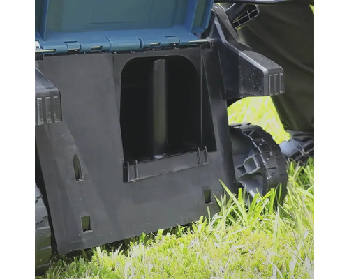 Detailansicht eines Vertikutierers mit geöffnetem Fangkorb auf Rasen