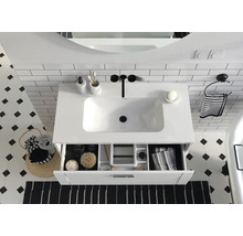 Badezimmer Waschbecken mit offenem Schubladenelement, ergänzt durch Accessoires für eine stilvolle Einrichtung.