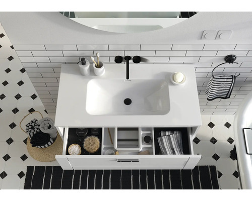 Badezimmer Waschbecken mit offenem Schubladenelement, ergänzt durch Accessoires für eine stilvolle Einrichtung.