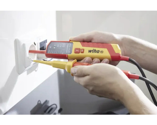 Elektriker prüft Steckdose mit zweipoligem Spannungsprüfer von Wiha