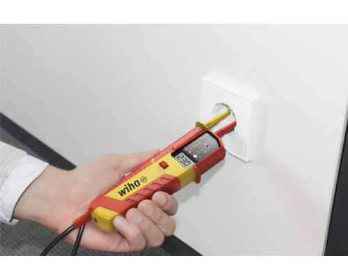 Eine Hand testet mit einem zweipoligen Spannungsprüfer eine Steckdose. Wiha Logo.