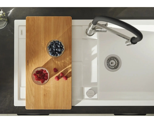 Küchenspüle mit Schneidebrett, Armatur und frischen Beeren