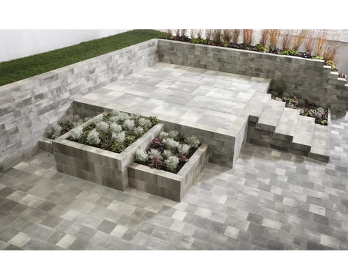 Gartenanlage mit Pflastersteinen, Treppe und bepflanzten Hochbeeten