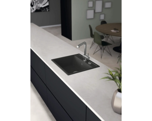 Schwarzes Spülbecken mit Armatur auf einer Küchenarbeitsplatte.