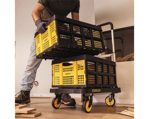 Mann transportiert faltbare Transportkisten von Stanley auf einem Transportwagen