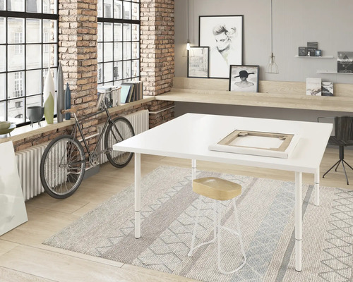 Heller Raum mit großem Fenster, Atelier Tisch, Hocker und Dekorationen.