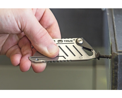 Ein Mann benutzt einen silberfarbenen Multifunktionsschlüssel, um eine Schraube festzuziehen.