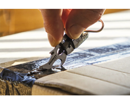 Eine Hand öffnet mit einem Sharkey 12-in-1-Multifunktionswerkzeug einen Karton