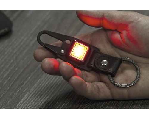 Schlüsselanhänger mit LED-Leuchte in einer Hand