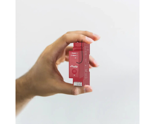 Eine Hand hält ein rotes Shelly-Gerät zur Hausautomation