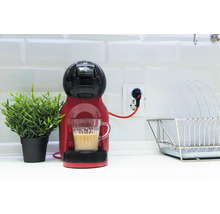 Kaffeemaschine mit Tasse Kaffee, Zimmerpflanze und Abtropfgestell in der Küche