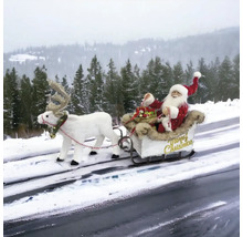 Weihnachtsmann mit Rentierschlitten als Dekoration im Schnee