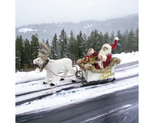 Weihnachtsmann mit Rentierschlitten als Dekoration im Schnee