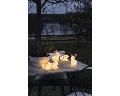 Dekorative Hasenfiguren mit Beleuchtung auf einem Gartentisch