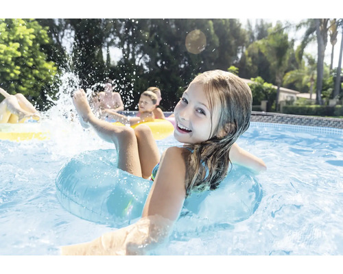 Szene in einem Pool mit spielenden Kindern und Schwimmringen.