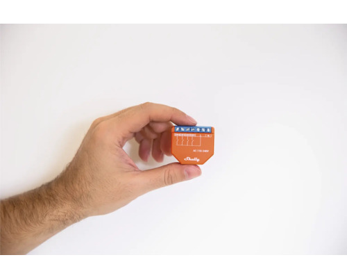 Eine Hand hält einen Shelly-Schalter.