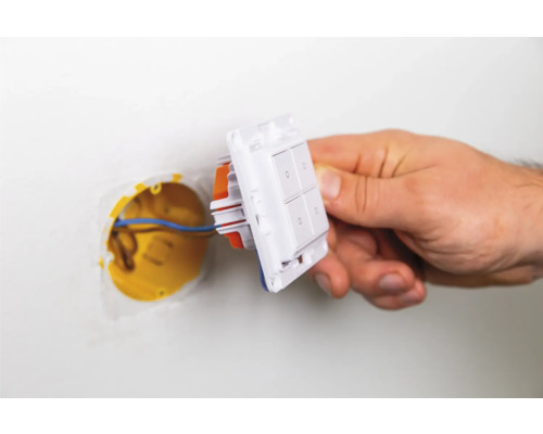 Installation eines Lichtschalters mit vier Schaltern an einer Wand