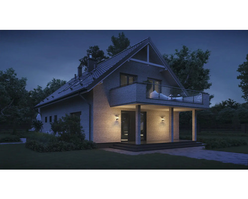 Haus mit Balkon und Außenbeleuchtung in der Abenddämmerung