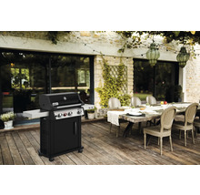 Weber Grill auf einer Terrasse mit Esstisch und Stühlen