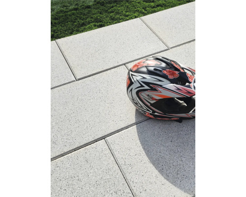 Ein Fahrradhelm liegt auf Steinplatten.