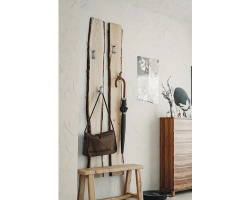 Garderobe aus Holz mit Tasche und Regenschirm an der Wand montiert über einer Holzbank.