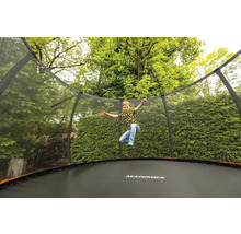 Kind springt auf einem Marimex Trampolin mit Sicherheitsnetz im Garten