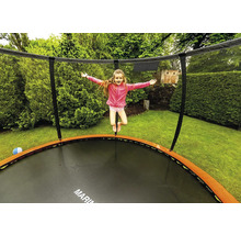 Mädchen springt auf einem Gartentrampolin mit Sicherheitsnetz