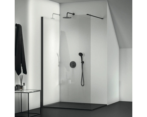 Ebenerdige Dusche mit Glaswand und schwarzer Armatur in einem Badezimmer.