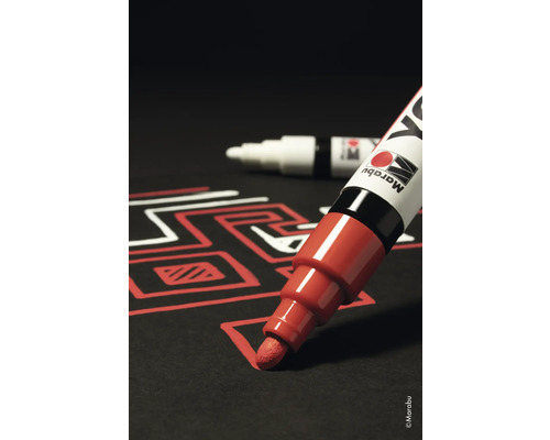 Roter Lackmarker zeichnet auf schwarzem Untergrund ein Muster, im Hintergrund weiterer Marker.