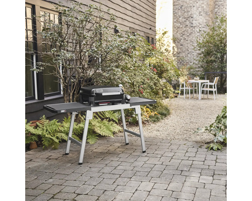 Weber Grill auf einem Tisch im Garten.