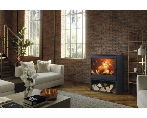 Wohnzimmer mit Kaminofen, Holzscheiten und Ziegelwand