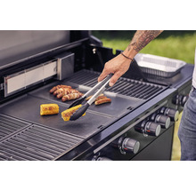 Person grillt Mais und Würstchen auf einem Grill.