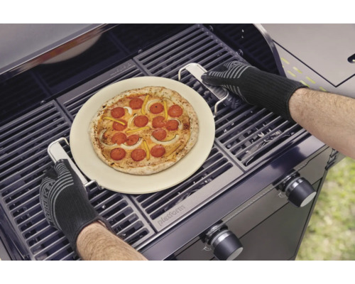 Pizza auf Pizzastein wird mit Grillhandschuhen auf Grill zubereitet.