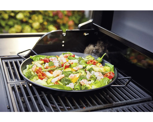 Gemüse und Garnelen in einer Grillpfanne auf einem Grill