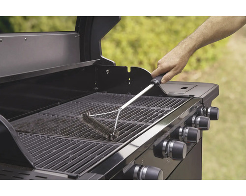 Eine Grillbürste wird verwendet, um einen Grillrost zu reinigen.
