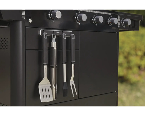 Detailansicht eines schwarzen Gasgrills mit Grillbesteck