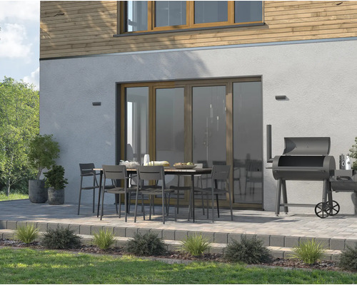 Terrasse mit Gartentisch, Stühlen und Grill vor einem Haus