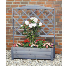Blumenkasten mit Rankgitter vor einer Ziegelwand