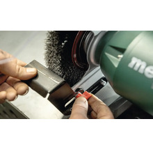 Metallstück wird mit einer Drahtbürste an einer Schleifmaschine bearbeitet