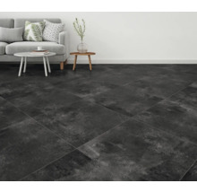 Wohnzimmer mit Sofa und dunklen Bodenfliesen.