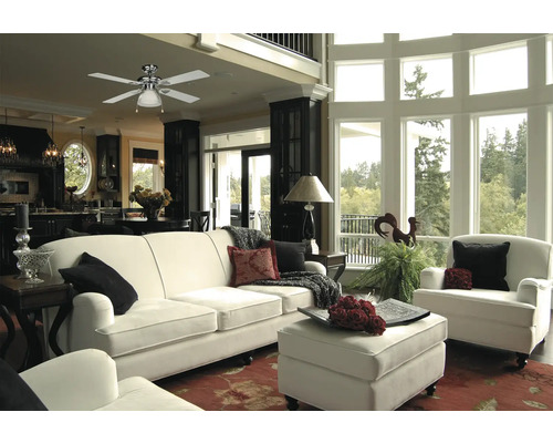 Heller Wohnraum mit Deckenventilator, Sofa und Sesseln