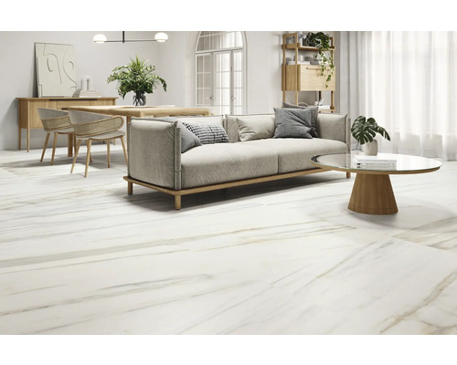 Heller Wohnraum mit Bodenfliesen in Marmoroptik, Sofa, Tisch und Stühlen.