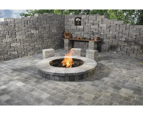 Gestalteter Außenbereich mit Feuerstelle, Mauer, Pflastersteinen und Sitzgelegenheiten