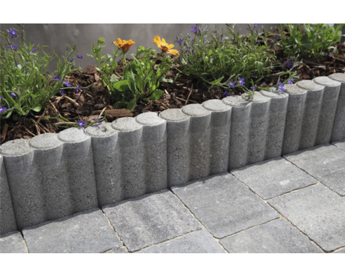 Beeteinfassung aus Beton mit Pflanzen und Pflastersteinen