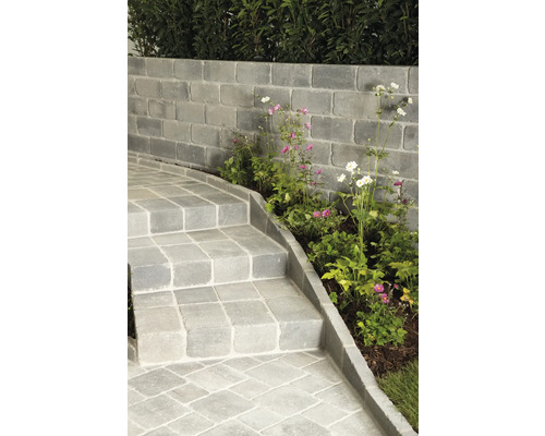 Außenbereich mit Mauer aus Betonsteinen, Treppe und Bepflanzung