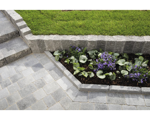 Gartenanlage mit Pflastersteinen, Treppe, Rasen und Blumen