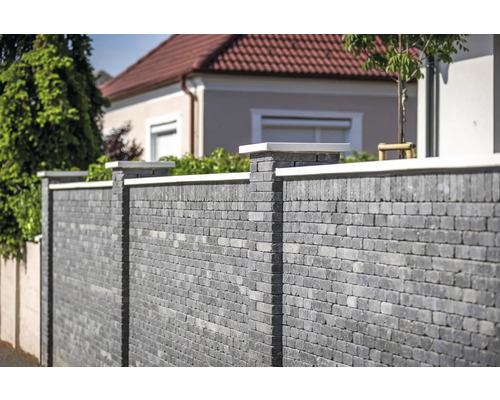 Graue Steinmauer mit Säulen und Abdeckung im Garten