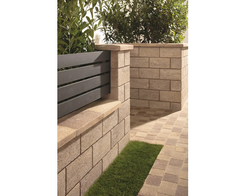 Gartenszene mit Mauer aus Betonsteinen, Holzzaun und Pflastersteinen