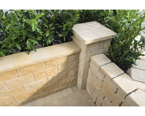 Gestaltung eines Gartens mit Pflastersteinen und einer Mauer aus Sandstein